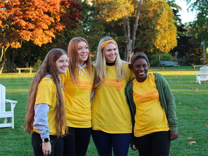 Four young women in yellow t-shirts