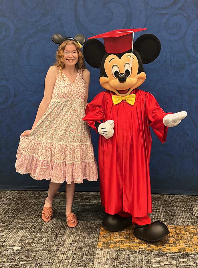 Young woman with Mickey Mouse at graduation ceremony