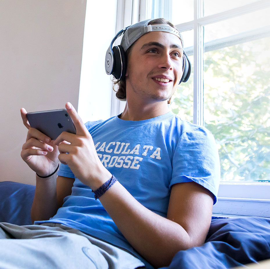 Student in dorm room with headphones on