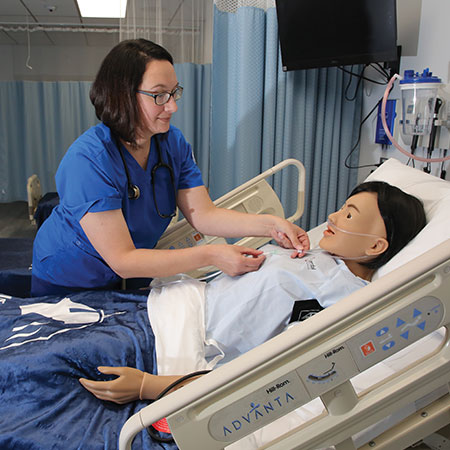 Immaculata University Adult and Professional Degrees nursing student working with a mannequin