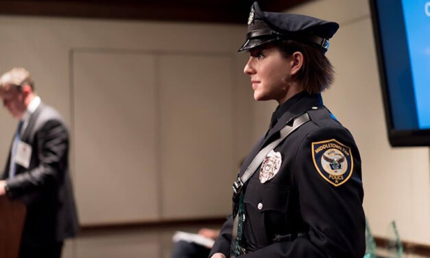 A police woman in uniform accepting an award