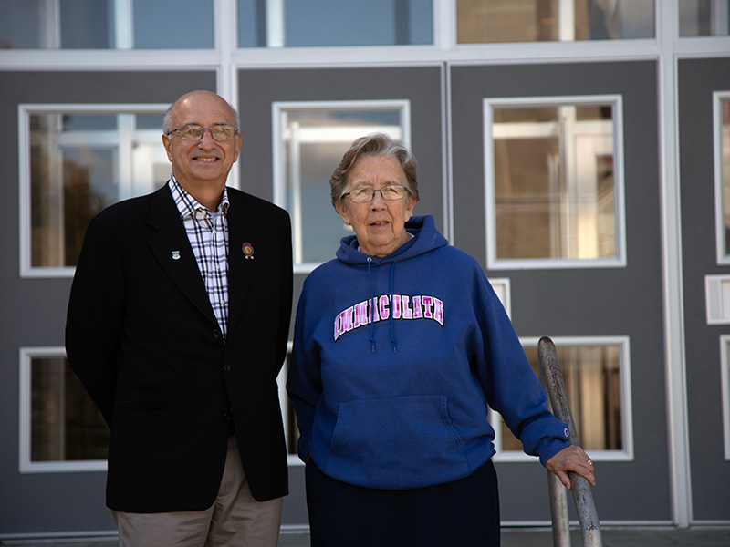 Older man and woman standing in front of building