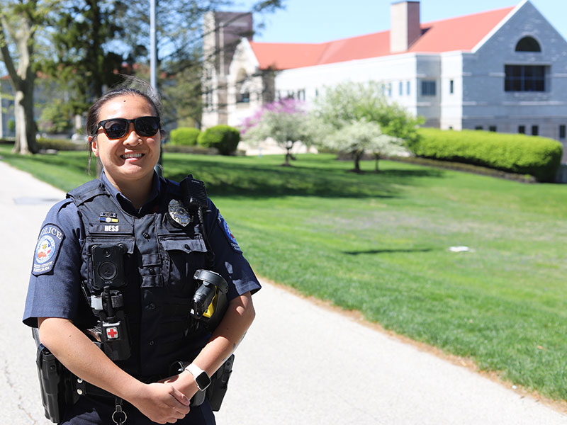 Woman in police uniform in front of campus building