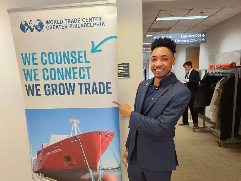 Man at expo in front of banner