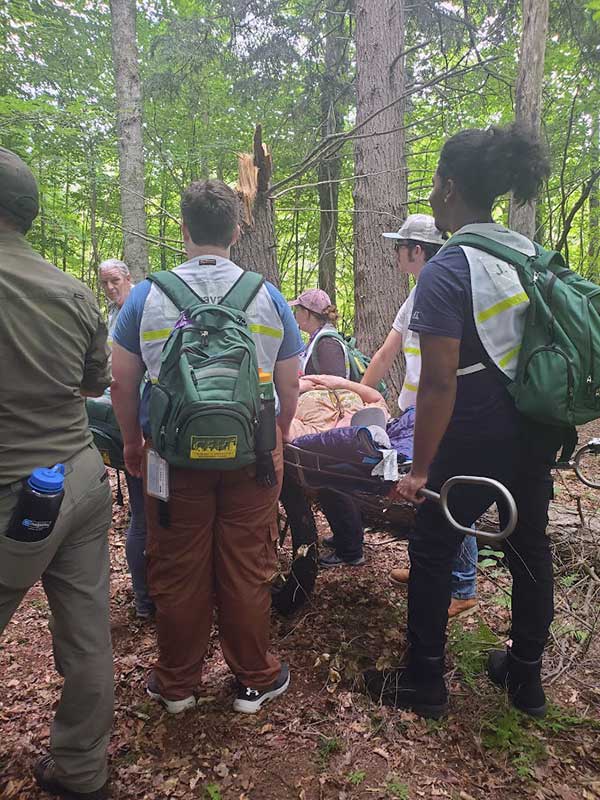 hiker-rescue - Immaculata University Group of people carrying stretcher out of woods