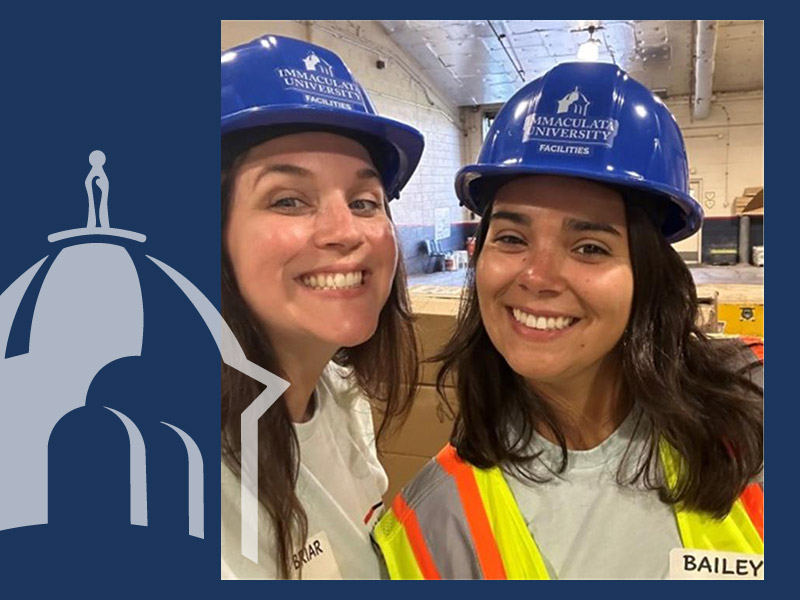 Two women in hard hats with Immaculata University logo