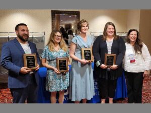 Five people holding award plaques