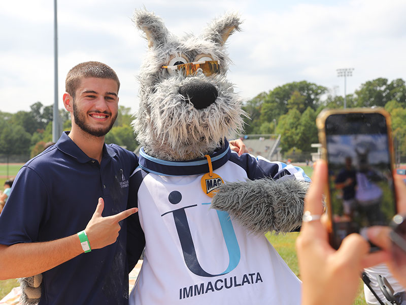 Person with phone taking photo of man with mascot
