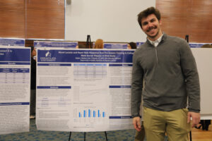 College student in front of research poster