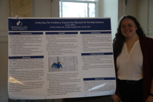 College student in front of research poster