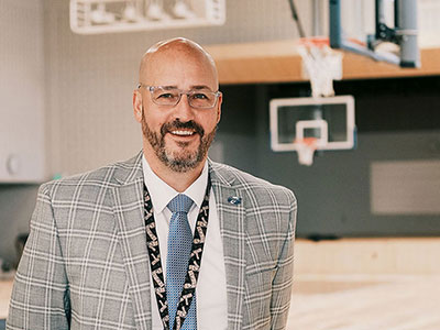 Man in suit standing in school gym