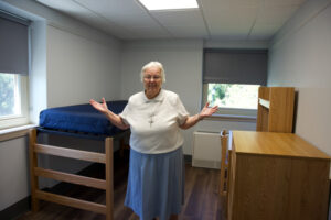 A nun standing in a dorm room