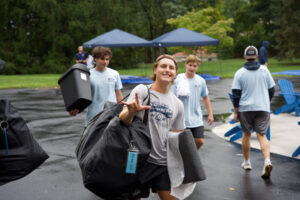 Young woman carrying items to move into dorm