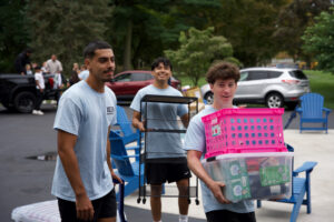 Young men carrying items to move into dorm