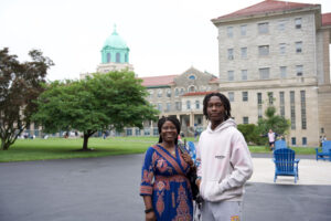 Woman and young man in front of college building