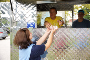 A woman getting her meal from a food truck