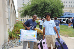 People carrying items to move into dorm