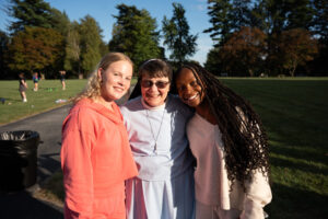 Two young women on each side of a nun