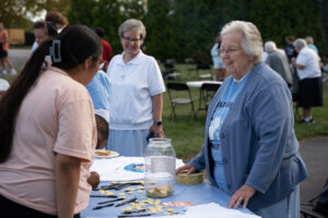 College students making s'mores and talking to nuns