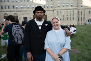Young man standing next to nun