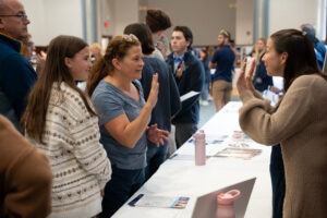 People at open house speaking to woman behind a table
