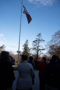 People outside around a flagpole