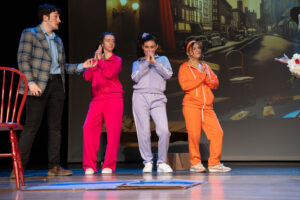 Actors on stage in costume (man and three women)