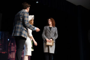 Actors on stage in costume (man and two women)