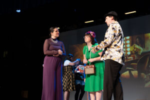 Actors on stage in costume (man and two women)