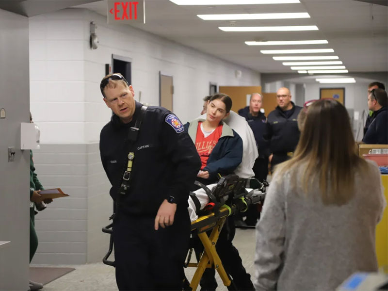 Immaculata student on a stretcher accompanied by members of the East Whiteland Township Fire and Rescue, including Captain Nafziger , as part of the IU disaster simulation event.