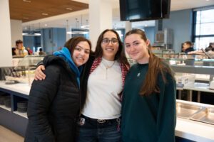 Three young women in college dining hall