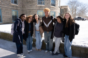 Group of college students with arms around one another on snowy campus