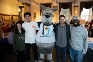 Mascot with arms around college students