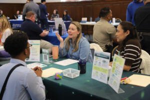 Two woemn at a table talking to a student