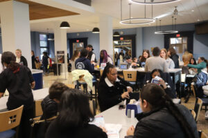 A large crowd of parents and students in a college dining hall