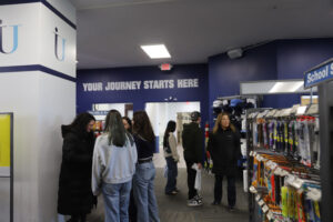 A group of people looking at clothing in a college store