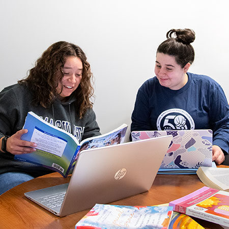 Immaculata University Learning Support Services - two female students at desk studying with laptops